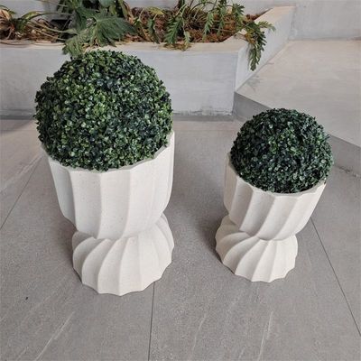 Plantación redonda de fibra de arcilla en estilo moderno con superficie texturizada y material resistente a las condiciones climáticas